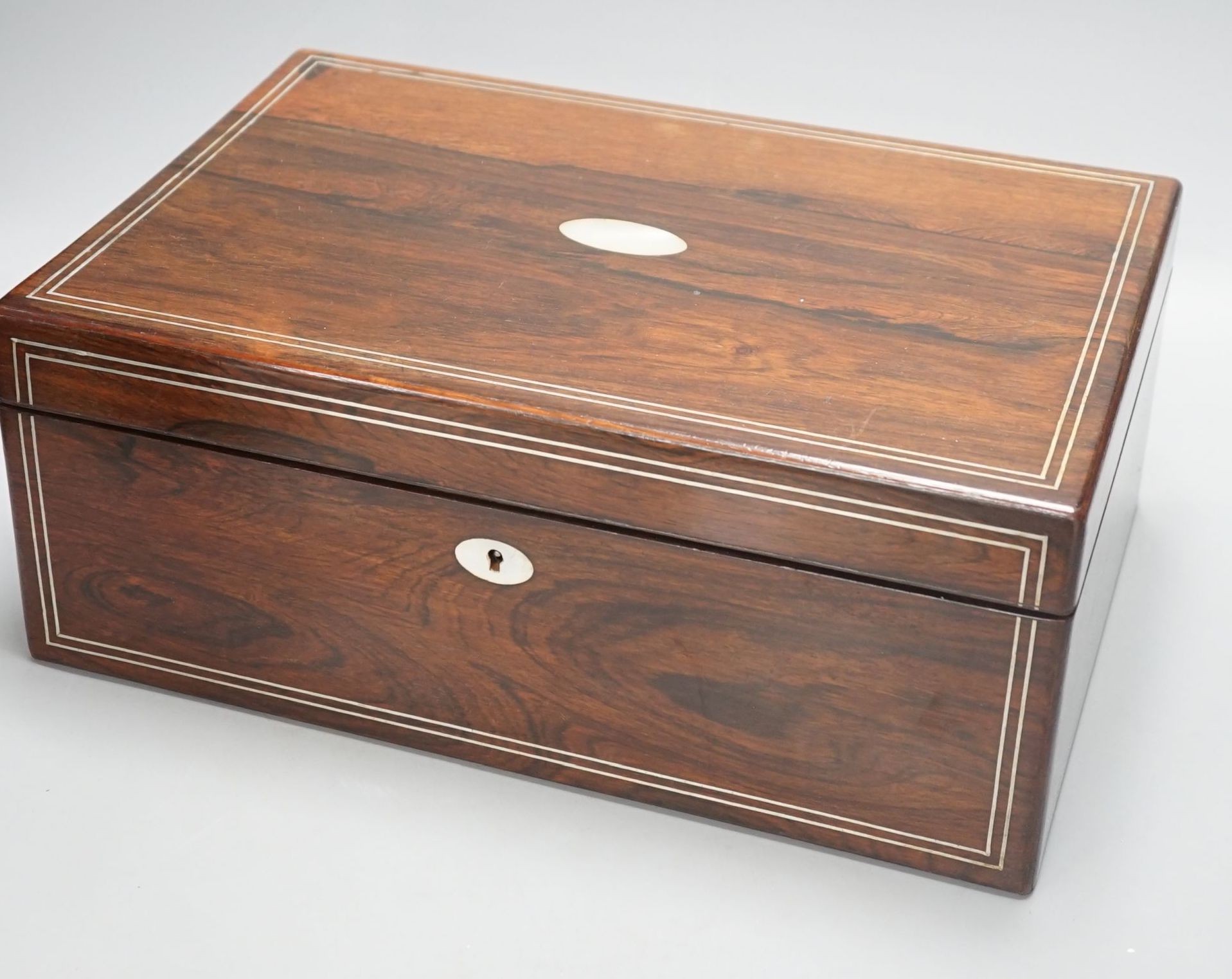 A Victorian rosewood sewing box containing white metal lidded glass bottles, box 37 cms wide x 15 cms high.